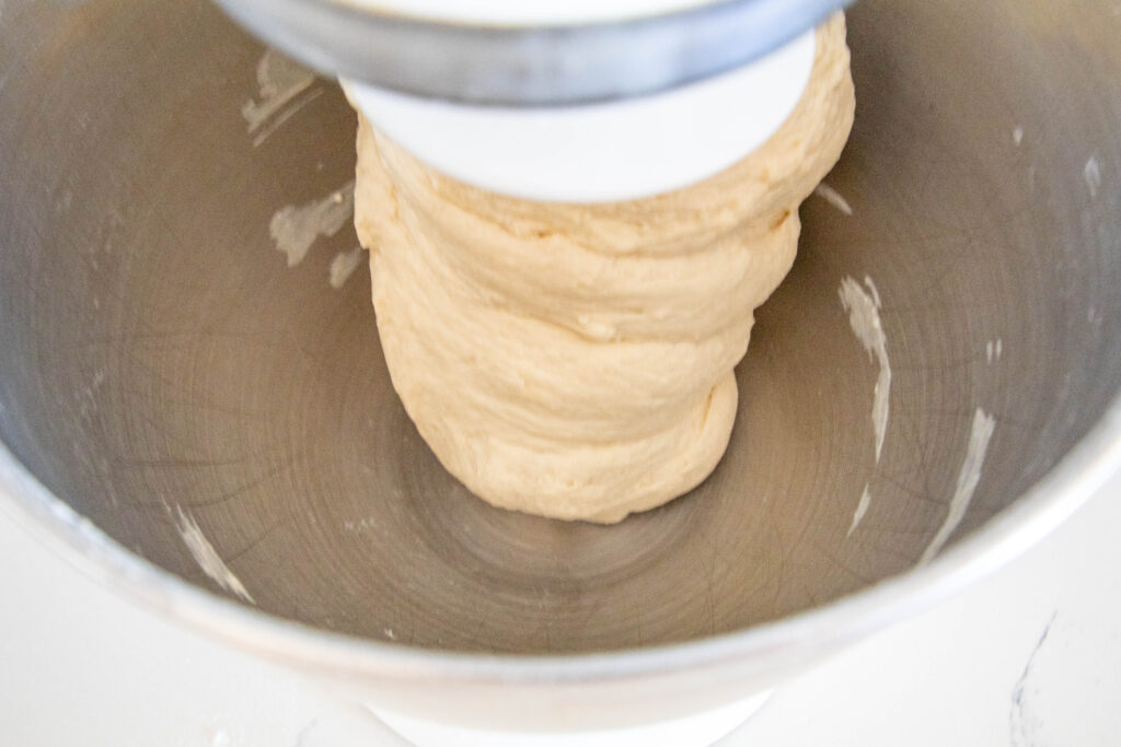 mixing bowl with kneaded bread dough on dough hook