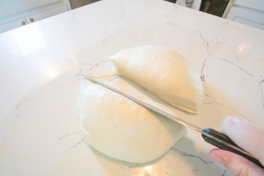 knife cutting dough ball in half (process shot)