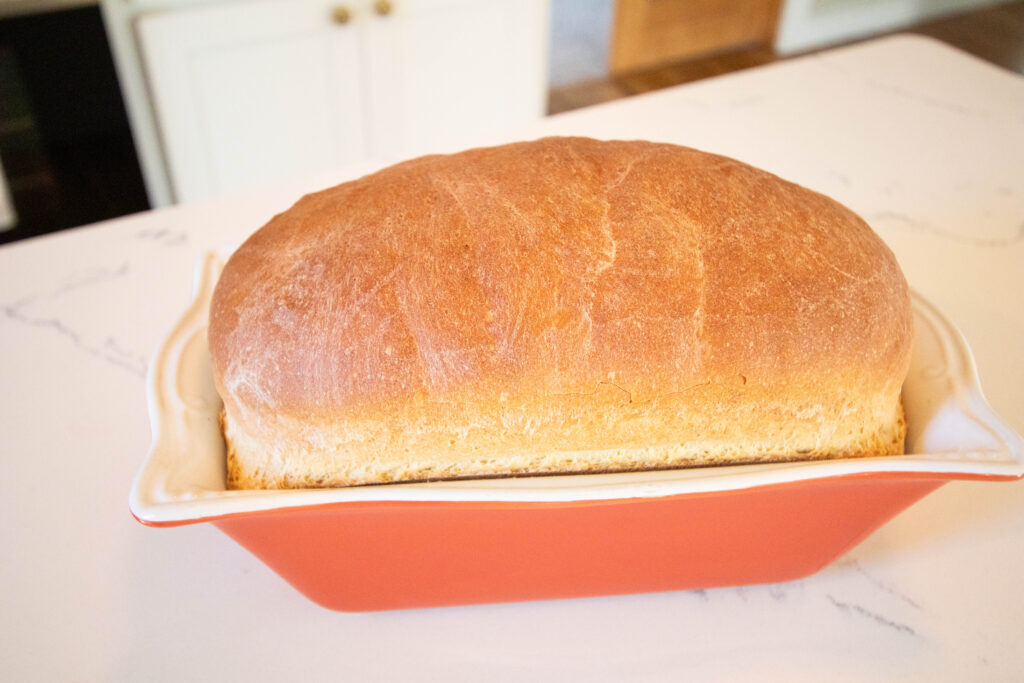 freshly baked homemade sandwich bread in orange bread pan