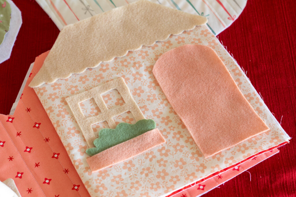 Fabric doll house with felt accents.