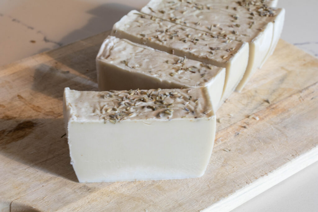 Freshly cut creamy colored soap bars topped with dried lavender. 