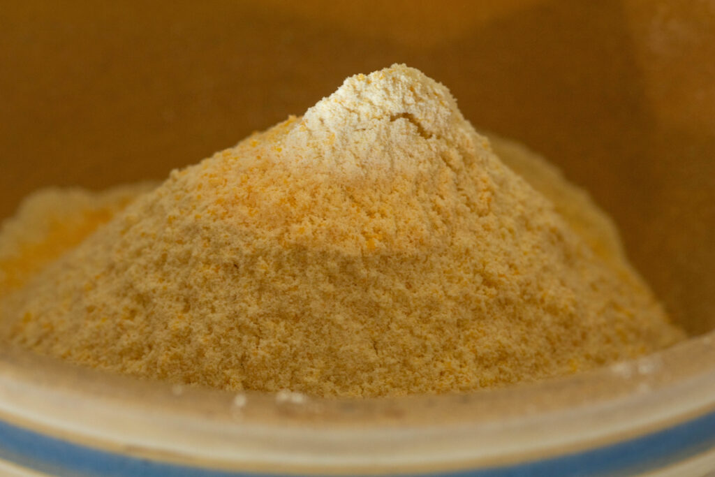 Vintage stone bowl with einkorn cornbread ingredients in side.