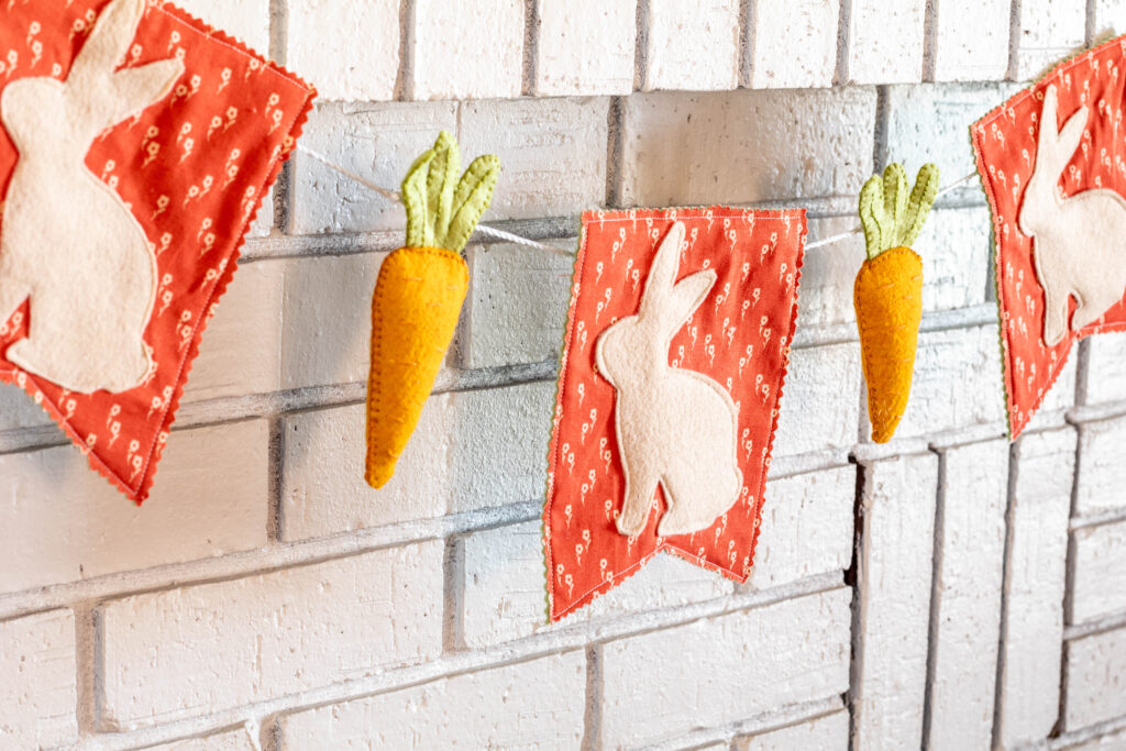 DIY Easter Garland strung up on white brick fireplace.
