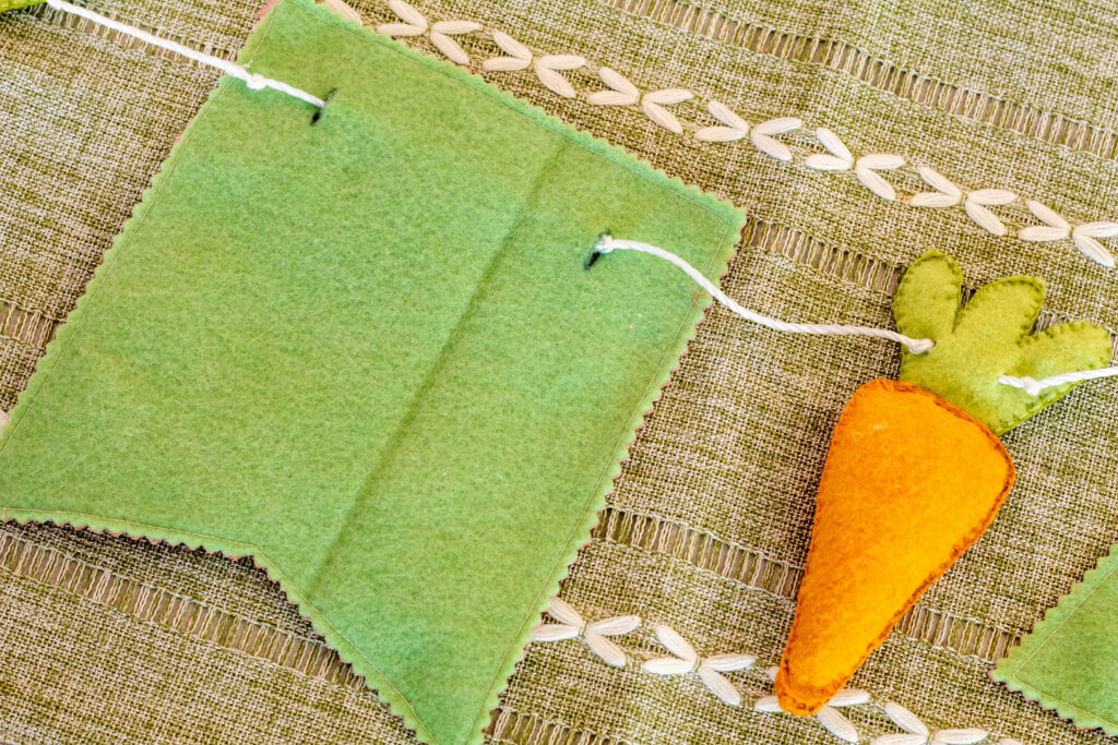 DIY easter garland view from behind with twine strung through carrot and bunting.