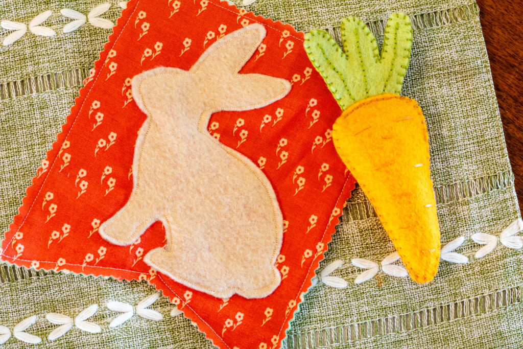 Finished bunny bunting and felt carrot on green embroidered place mat.